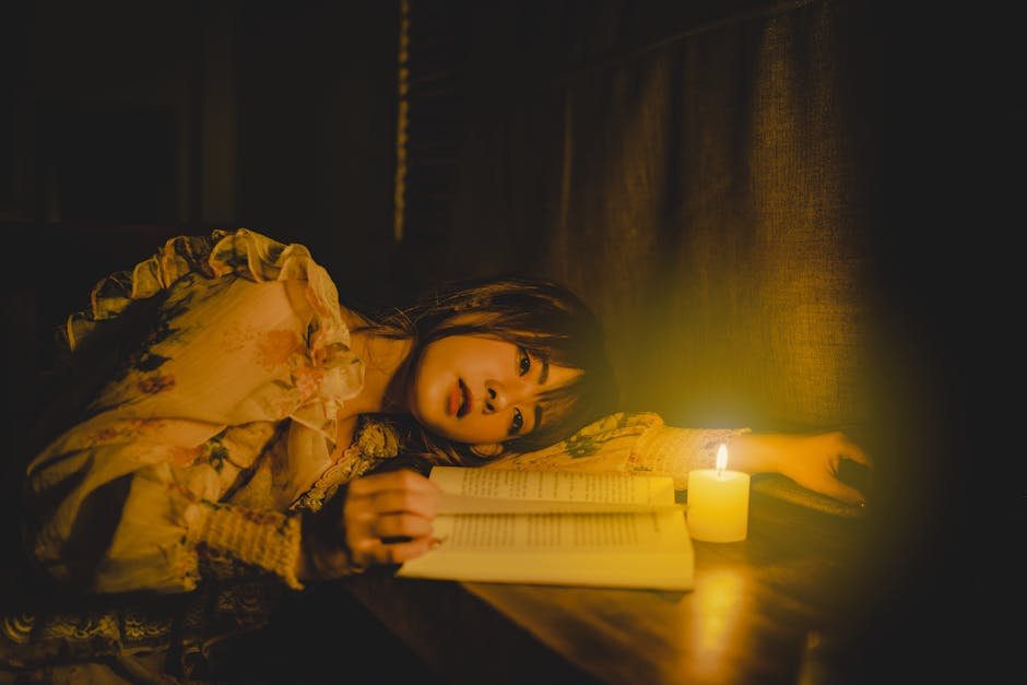 A woman reading a book by candlelight, creating a warm, intimate ambiance.